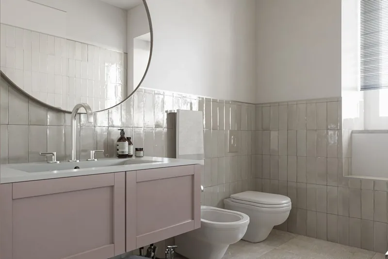 Bagno con mobile rosa antico e piastrelle lucide